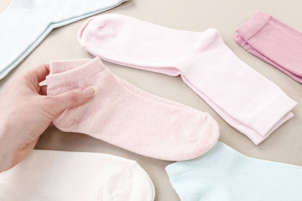 The woman arranges the washed socks. Clothing time - 写真・画像
