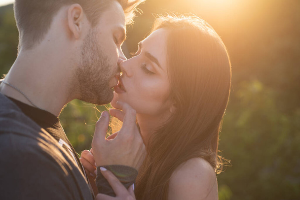 Man with woman kisses. Close up portrait of a beautiful young couple waiting to kiss against sunset light. - Fotoğraf, Görsel