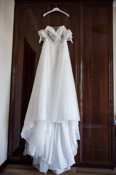 a bride's wedding dress hanging on the wardrobe - Fotografie, Obrázek
