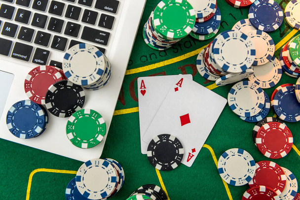 オンラインポーカーやカジノのギャンブルのためのチップ、カードのお金とラップトップ。賞金獲得のリスク - 写真・画像