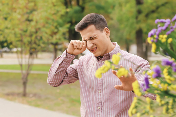 Giovane uomo affetto da allergia al polline all'aperto - Foto, immagini