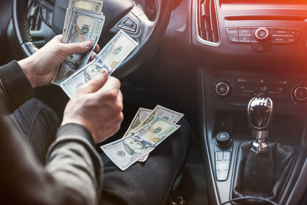 Człowiek w jego samochodzie liczy nam rachunki za zapłatę. koncepcja finansowania - Zdjęcie, obraz