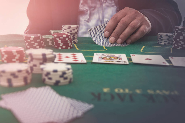 mies pelata kasinolla pelikortteja ja pelimerkkejä vihreässä pöydässä. rahapelit - Valokuva, kuva