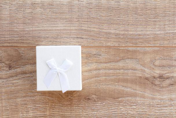 Белый подарочный ящик на деревянных досках. Вид сверху. Концепция дарения подарков в праздничные дни. - Фото, изображение
