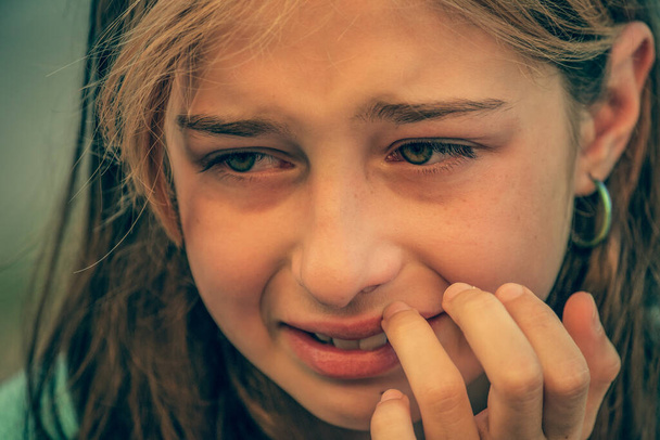 Bella bambina triste che piange, sullo sfondo estivo. Ragazza che piange. Ritratto di una ragazza triste da vicino - Foto, immagini