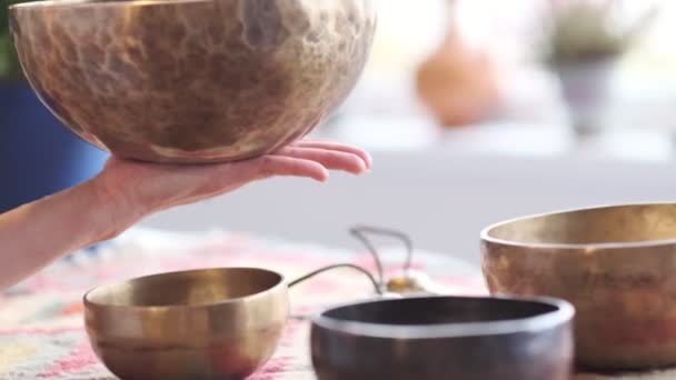 Woman playing on Tibetan singing bowl while sitting on yoga mat. Vintage tonned. stock footage. Slow Motion video. Close up - Footage, Video