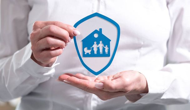 Concept of family and house insurance with paper shield held by female hand - Photo, Image