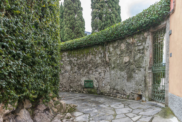 Europa, Itália, Varenna, Lago de Como, um edifício de pedra que tem árvores em torno dele - Foto, Imagem