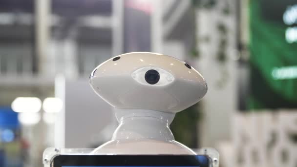 Lähellä liikkuvaa humanoidirobottia, jolla on kamera päässä. Media. Uusi teknologinen robotti liikkuu näyttelykeskuksessa, tulevaisuuden teknologiat. - Materiaali, video