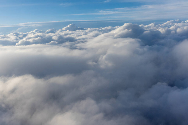 View of clouds from airplane window, a plane flying through a cloudy sky - Foto, afbeelding