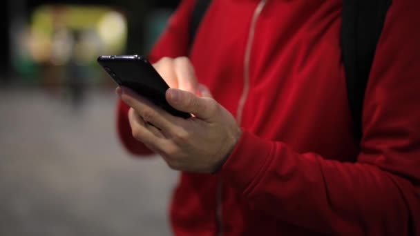 Personne méconnaissable avec smartphone dans le parc - Séquence, vidéo