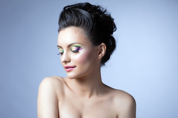Pretty girl with evening make-up posing in studio - Fotó, kép