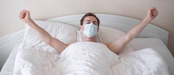 Man wakes up in the morning wearing a protective mask in covid-19 - Photo, Image