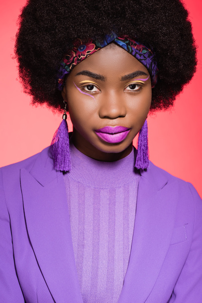 african american young woman in purple stylish outfit isolated on red background - Foto, Imagem