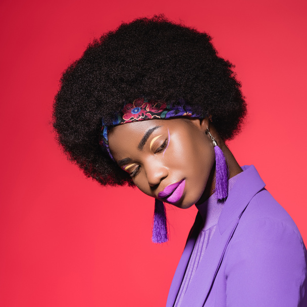 african american young woman in purple stylish outfit isolated on red - Foto, Imagem