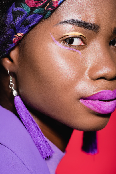 closeup of african american young woman in purple stylish outfit isolated on red - Φωτογραφία, εικόνα
