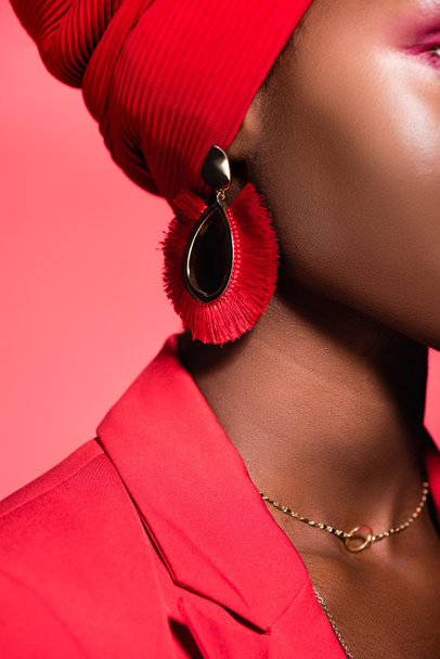 közelkép afro-amerikai fiatal nő fülbevaló elszigetelt piros - Fotó, kép
