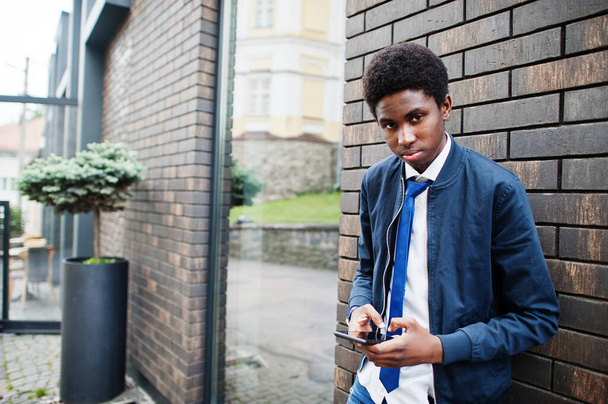 African man wear in tie and casual outfit posing outdoor with mobile phone. - Photo, image