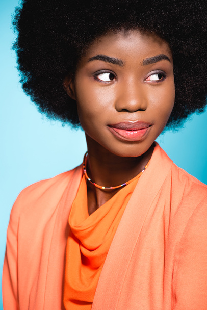 african american young woman in orange stylish outfit isolated on blue - Foto, Imagem