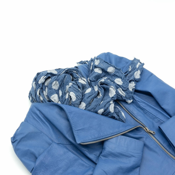 Damenjacke aus blauem echtem weichem Leder. Verschluss - schräger Reißverschluss. Accessoire - dunkelblauer Schal mit weißen Kreisen. Isoliert auf weißem Hintergrund. - Foto, Bild