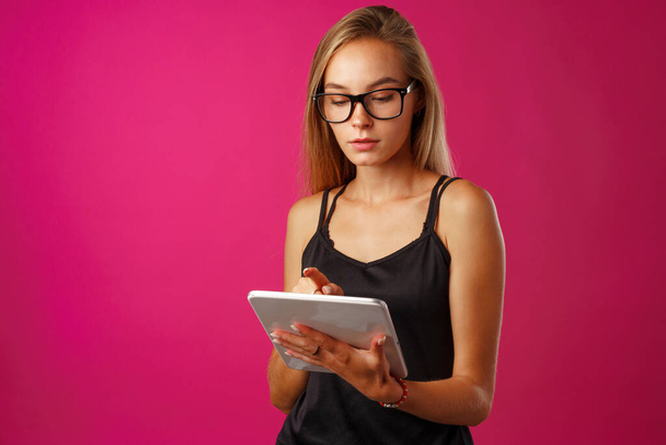 Beautiful young woman in glasses using digital tablet - Foto, afbeelding