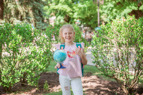roztomilý školačka držící glóbus v parku  - Fotografie, Obrázek