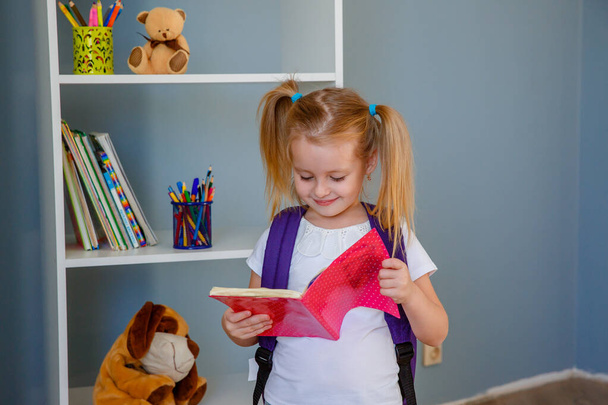 koncepce do školy vzdělávání. Malá holčička s knihou a jablkem v rukou - Fotografie, Obrázek
