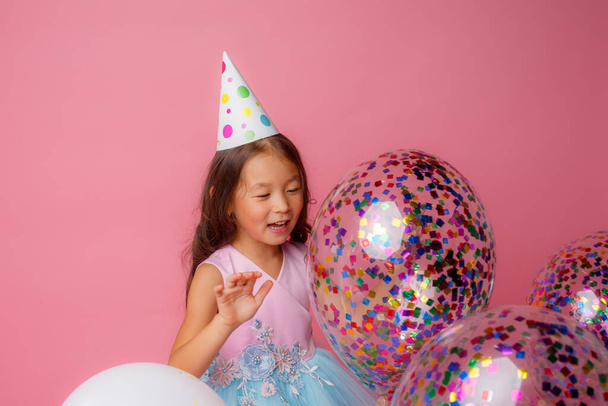 cumpleañera posando con globos contra rosa - Foto, imagen