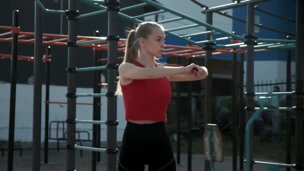 ajustement sportif caucasien jolie fille séance d'entraînement dans les vêtements de sport en plein air au terrain de sport - Séquence, vidéo