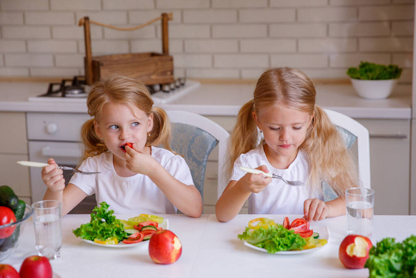 Çocuklar mutfakta sağlıklı yiyecekler yerler. - Fotoğraf, Görsel