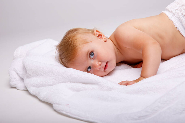 Onnellinen nuori vauva makaa vatsa eristetty valkoisella taustalla. - Valokuva, kuva