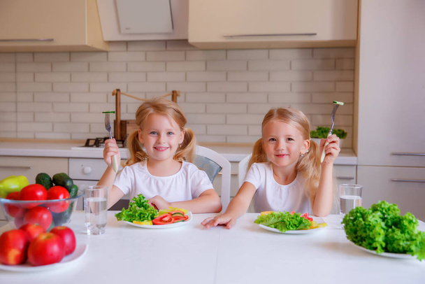 子供たちは台所で健康的な食べ物を食べ  - 写真・画像