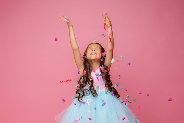 Ázsiai lány ünnepli születésnapi szopás fogások konfetti rózsaszín háttér - Fotó, kép