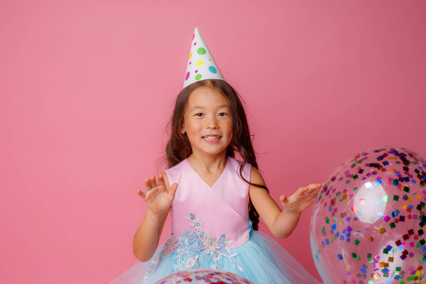 birthday girl posing with balloon against pink background - Фото, изображение