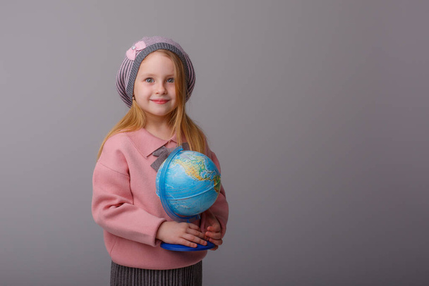 carino ragazza holding globo contro grigio  - Foto, immagini