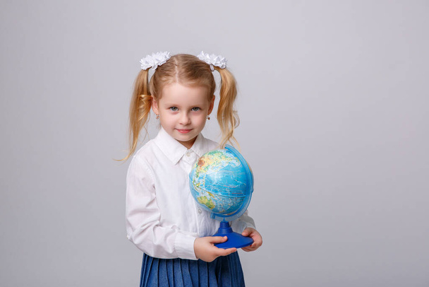 aranyos kislány gazdaság föld gömb fehér háttér - Fotó, kép