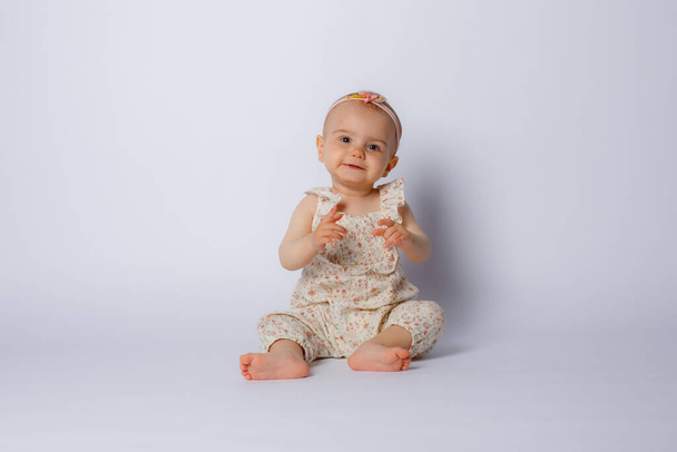 cute little baby girl sitting on the floor, isolated on white background - Photo, Image