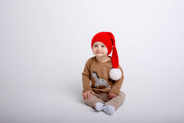little boy in santa hat posing in studio - Foto, afbeelding