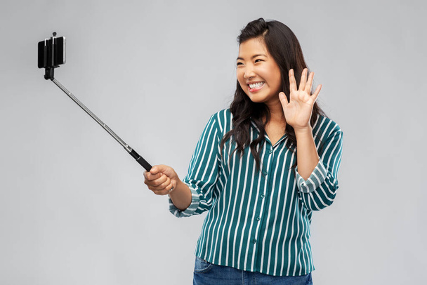 happy asian woman taking selfie and waving hand - 写真・画像