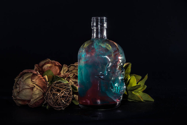 Skull bottle composition with colored water swirl  - Foto, afbeelding