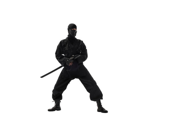 one japanese ninja in black uniform with katana sword, on white background, isolated - 写真・画像