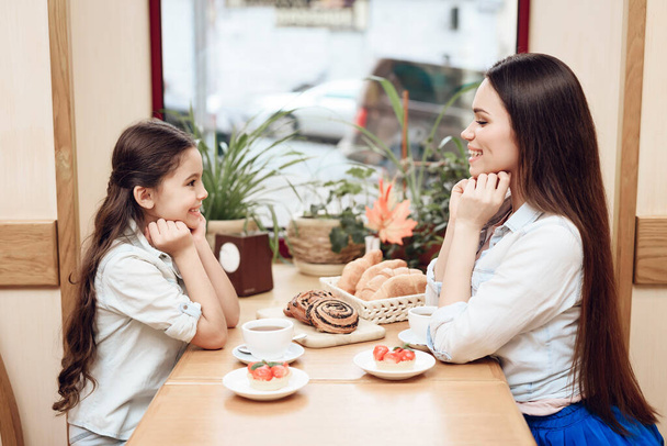 Mother with Daughter Eating Cakes in Cafeteria. - Foto, imagen