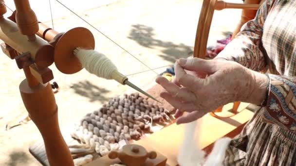 Hilados hechos en casa en cámara lenta hechos de lana en una rueda - Imágenes, Vídeo