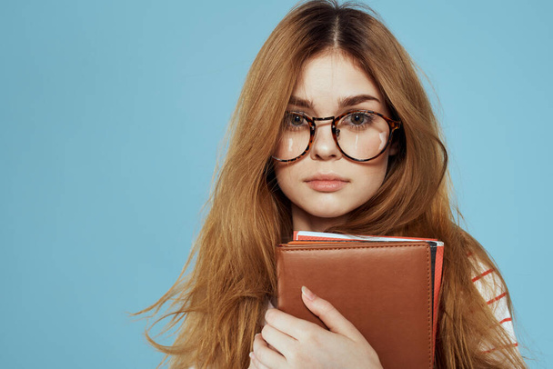estudante feminino enérgico com blocos de notas e óculos modelo fundo azul - Foto, Imagem