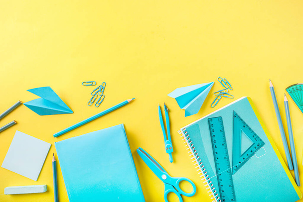 Group of blue school supplies on yellow background. Top view. Copy space. - Photo, Image