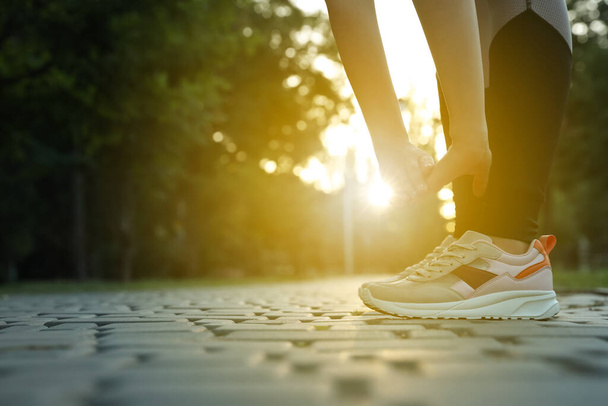 Γυναίκα που τεντώνεται πριν το πρωινό τρέξιμο στο πάρκο, κοντινό πλάνο. Χώρος για κείμενο - Φωτογραφία, εικόνα