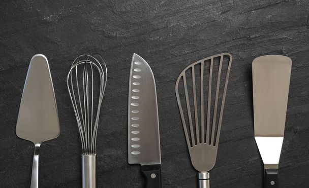 Cooking utensils on black table, flat lay - Foto, imagen