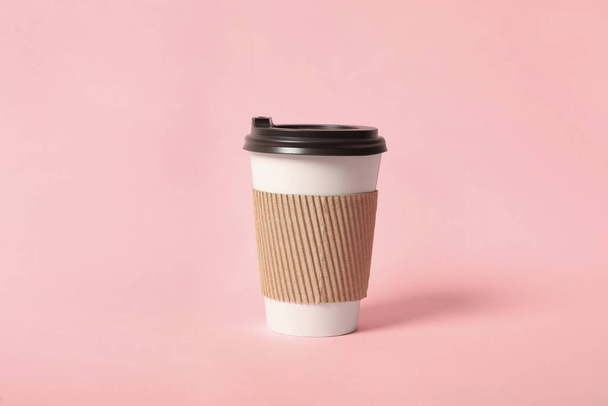 Takeaway paper coffee cup with cardboard sleeve on pink background - Fotó, kép