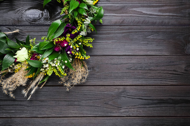 Beautiful wreath made of flowers and leaves on wooden table, top view. Space for text - Fotografie, Obrázek