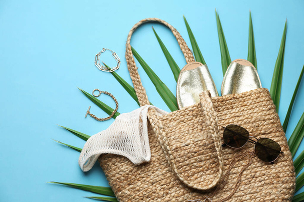 Flat lay composition with woman's straw bag on light blue background - Foto, Imagem